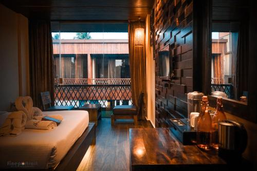 a room with a bed and a balcony with a window at Haywizz Havelock Island Resort in Havelock Island