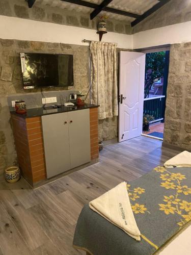 een kamer met een bed, een tv en een deur bij Yelagiri Villa in Yelagiri