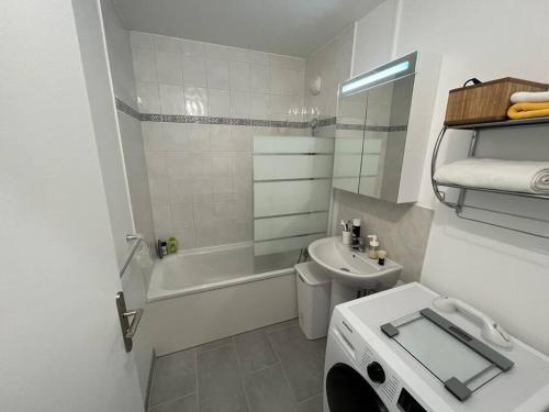 a bathroom with a sink and a toilet and a bath tub at Little Livia in Créteil