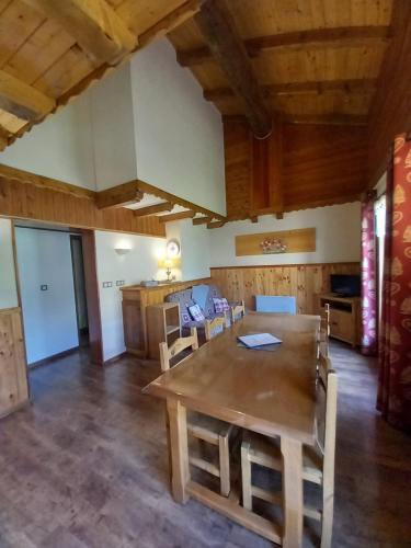 a dining room with a wooden table and chairs at Chalet l'aubépine résidence B&B in Bessans