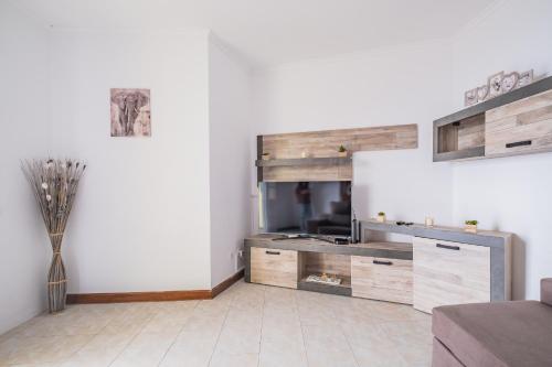 a living room with a large wooden entertainment center at The Balcony - By Wehost in Santa Cruz