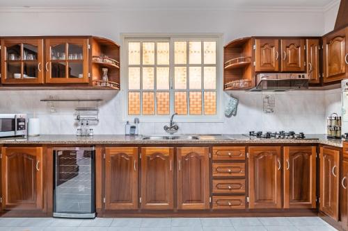 a kitchen with wooden cabinets and a sink at The Balcony - By Wehost in Santa Cruz