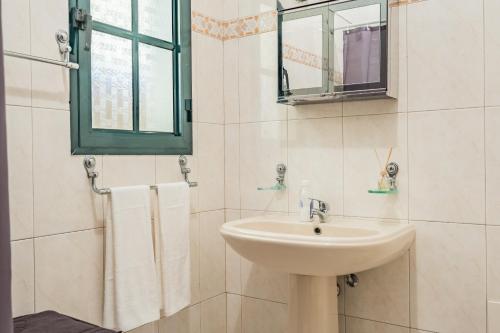 a white bathroom with a sink and a mirror at The Balcony - By Wehost in Santa Cruz
