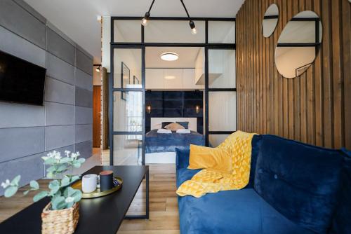 - un salon avec un canapé bleu et une table dans l'établissement Glow Apartments, Apartamenty Heaven Stare Miasto, à Gdańsk