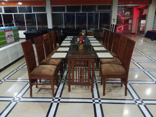 una larga mesa de madera con sillas en un restaurante en Hotel Red Roof & Restaurant, en Abbottābād