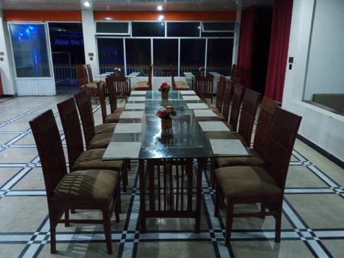 a long dining room with a long table and chairs at Hotel Red Roof & Restaurant in Abbottābād