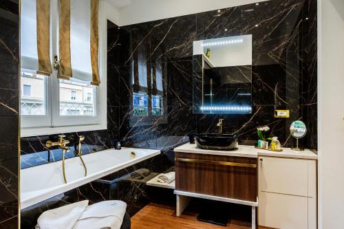 a bathroom with a bath tub and a sink at Maison d'Or in Genova