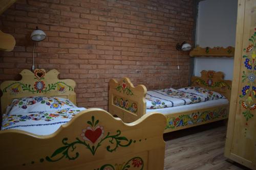 two beds in a room with a brick wall at Penzión na gazdovskom dvore in Dolný Kubín