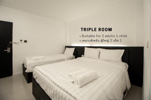 a bedroom with two beds with towels on them at The Nimman Hotel - SHA Plus in Chiang Mai
