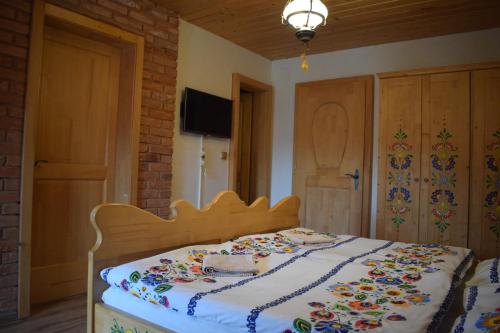 a bedroom with a bed with a floral blanket on it at Penzión na gazdovskom dvore in Dolný Kubín