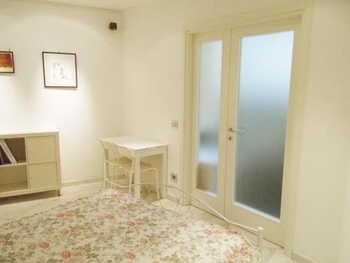 um quarto com uma porta de vidro deslizante e uma mesa em Tablinum em Bellagio