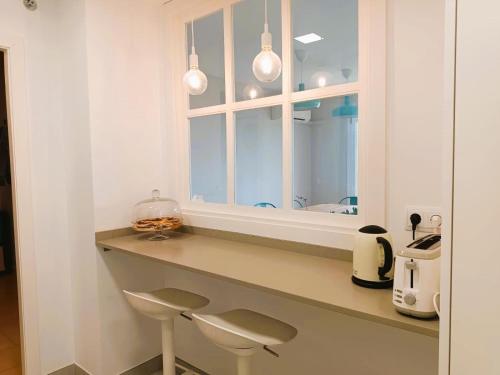 une cuisine avec un comptoir avec deux tabourets et un miroir dans l'établissement Villa Service - Coral III, à El Vendrell