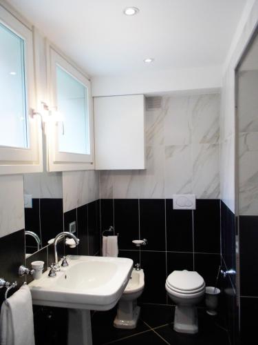 a bathroom with a white sink and a toilet at Tablinum in Bellagio