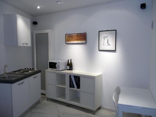 uma cozinha com um balcão e um micro-ondas na parede em Tablinum em Bellagio