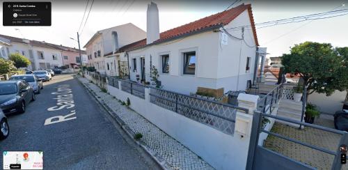 una strada con case bianche e auto parcheggiate sulla strada di Cantinho da Susana a Coimbra