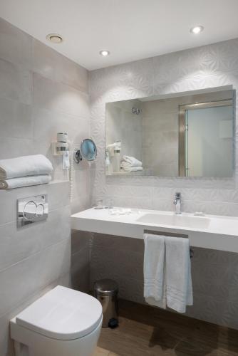 a bathroom with a sink and a toilet and a mirror at Catalonia Albeniz in Barcelona