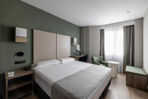una camera con un letto bianco e una parete verde di Catalonia Albeniz a Barcellona