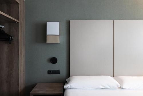 a bedroom with a bed and a headboard and a table at Catalonia Albeniz in Barcelona