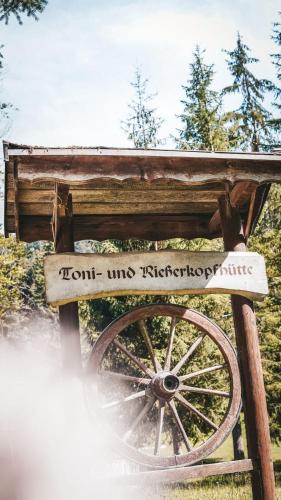 a wooden sign with a wheel in the grass at Toni Hütte am Riesserkopf in Garmisch-Partenkirchen