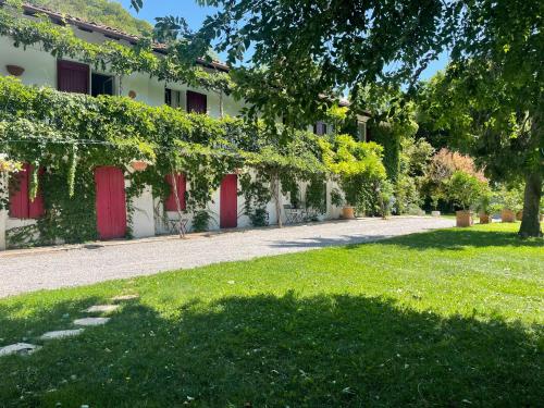 ein Gebäude mit roten Türen und einem grünen Hof in der Unterkunft GuestRoom Ia cascina di Bea in Torre Boldone