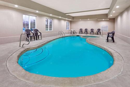 uma grande piscina com cadeiras num quarto de hotel em La Quinta by Wyndham Sulphur Springs em Sulphur Springs