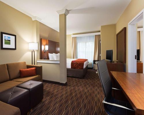 a hotel room with a bed and a living room at Comfort Suites DuBois Country Club in DuBois