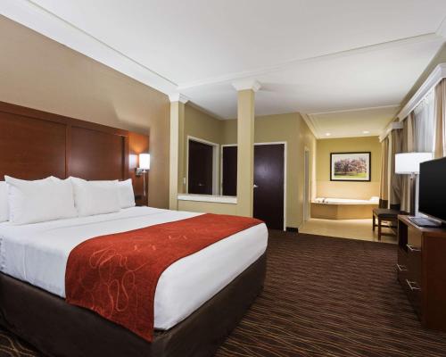 a hotel room with a bed and a flat screen tv at Comfort Suites DuBois Country Club in DuBois