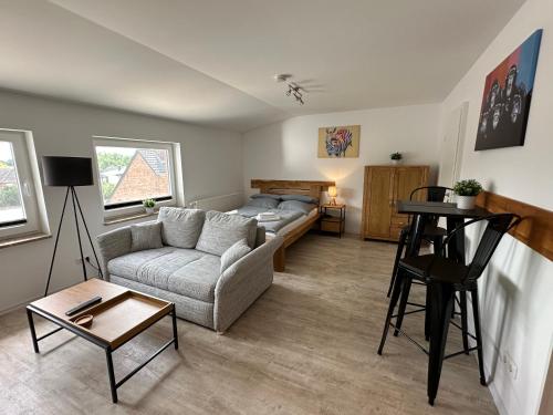 a living room with a couch and a bed at MEINpartments Wolfsburg in Wolfsburg
