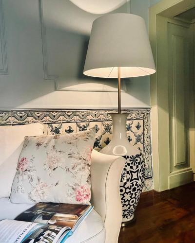 a lamp sitting next to a bed with a pillow at Palacio Ramalhete in Lisbon