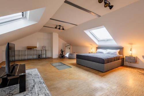 een slaapkamer op zolder met een bed en een televisie bij Luxus Loft I Wi-Fi I Gasgrill I Feldmarksee I 3 Schlafzimmer in Sassenberg