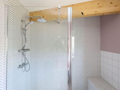 a shower in a bathroom with a geometric tile wall at Spacious 1-bed apartment with super king or twin in central Charlbury, Cotswolds in Charlbury