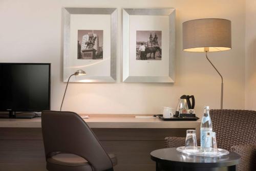 a room with a desk with a chair and a table at Ramada by Wyndham München Airport in Oberding