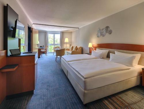 a hotel room with a large bed and a television at Dorint Seehotel Binz-Therme in Binz