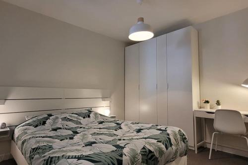 une chambre avec un lit, un bureau et une chaise dans l'établissement Appartement Terrasse 17 m² Centre historique, à Lons-le-Saunier
