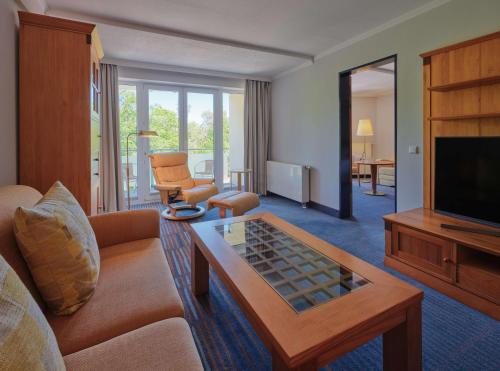 a living room with a couch and a television at Dorint Seehotel Binz-Therme in Binz