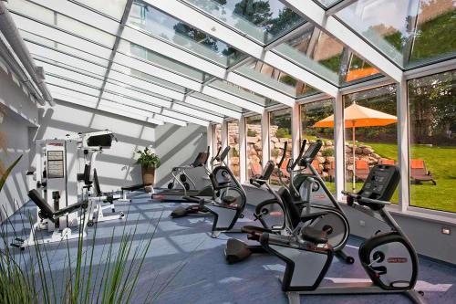 a gym with a row of tread machines in a building at Dorint Seehotel Binz-Therme in Binz