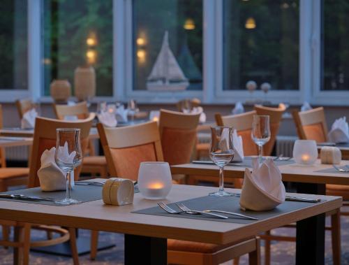 a restaurant with tables and chairs with glasses and candles at Dorint Seehotel Binz-Therme in Binz