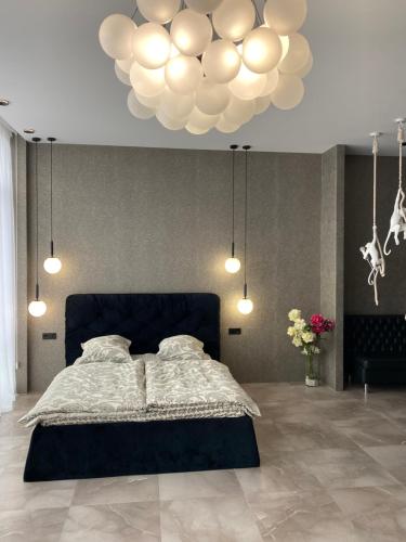 una camera con un letto e un grande lampadario a braccio di Apartment Delmar Lux ЦЕНТР a Dnipro