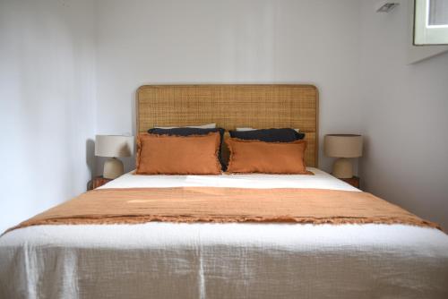 1 dormitorio con 1 cama grande con almohadas de color naranja en Vumba Agroturismo en Arganil