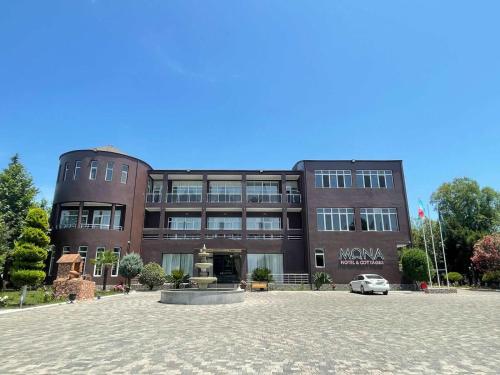 a building with a car parked in front of it at Mona Hotel and Cottages in Lankaran