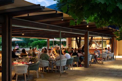 a group of people sitting at tables in a restaurant at Sheraton Lake Como Hotel in Como