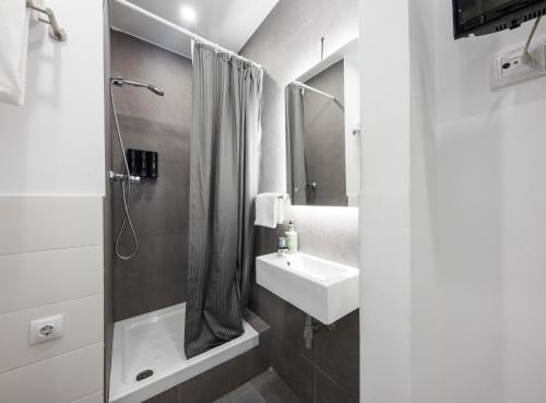 a white bathroom with a sink and a shower at No Limit Barcelona Central in Barcelona