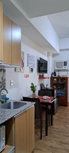 een keuken met een wastafel en een tafel bij Zhamira Avior's Condominium in Mactan