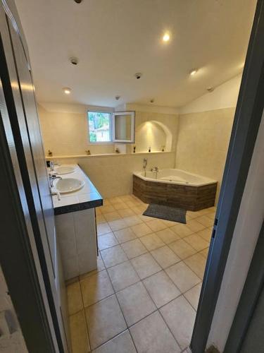 La grande salle de bains est pourvue d'une baignoire, d'un lavabo et d'une baignoire. dans l'établissement LE GITE LA BLAQUERE Bis, à Cendras