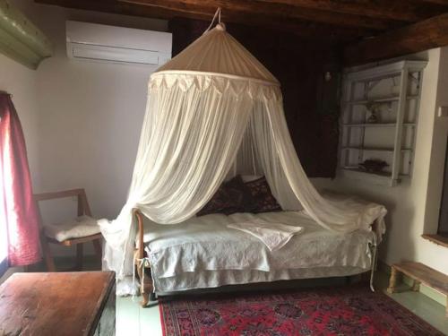 a bed with a canopy in a room at Kastellorizo- Casa Piero in Meyisti