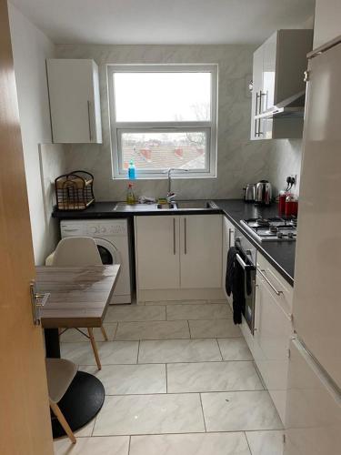 a small kitchen with a sink and a table at 2 Bedroom Flat with free parking in Manchester in Manchester