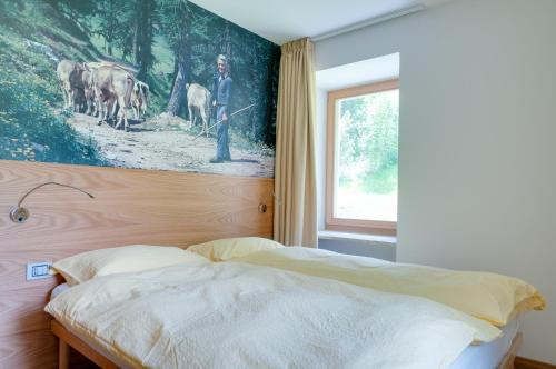 a bedroom with a bed with a painting on the wall at B&B Il Sorriso Dei Nonni in Pracorno di Rabbi