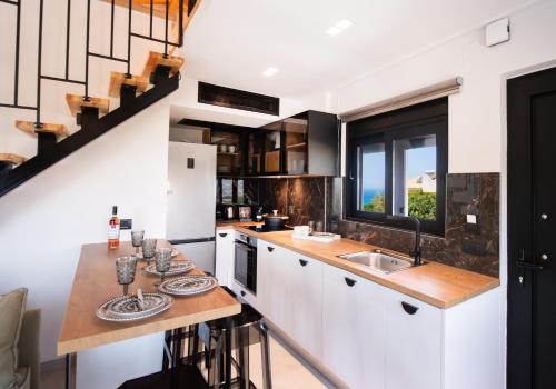 a kitchen with white cabinets and a counter with a sink at Solvio Boutique Hotel in Lefkada