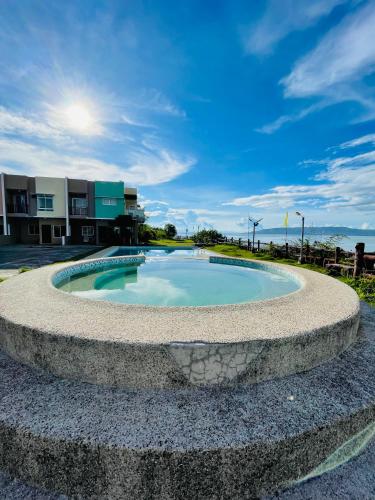 a circular pool with a stone wall around it at Nila's Staycation House in Dauis