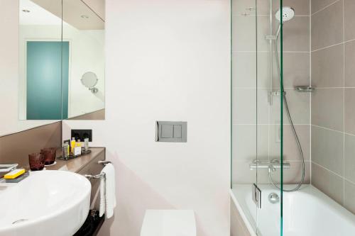 uma casa de banho com um lavatório e um chuveiro em Stuttgart Marriott Hotel Sindelfingen em Sindelfingen